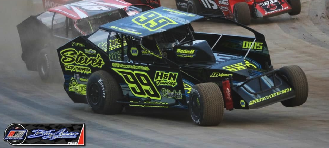 Car #99 racing in a pack on dirt track, multi-car battle